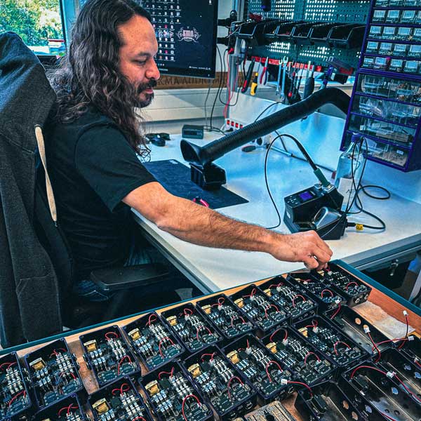 Picture of Marcelo assembling of a batch of QUEEQUEG 2 pedals, at the KMA factory in Berlin, 2023